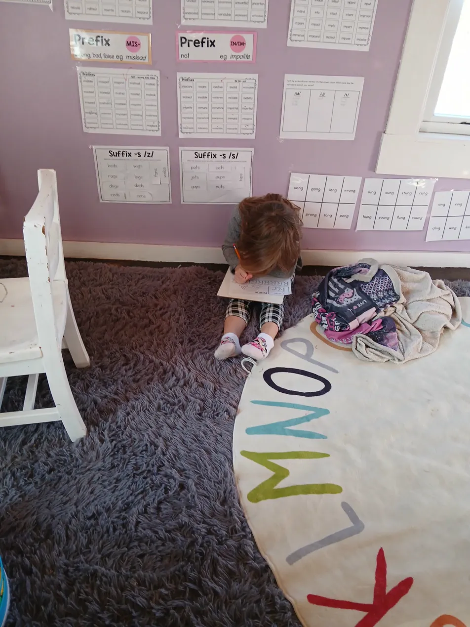Student working through prefix and suffix word cards on the wall